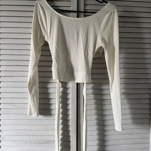 A beige/white crop top with cross and tie back